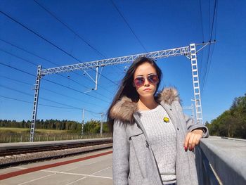 Young woman in sunglasses against clear blue sky