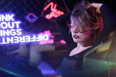 Side view of young woman looking through window