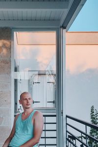 Portrait of young woman standing against sky