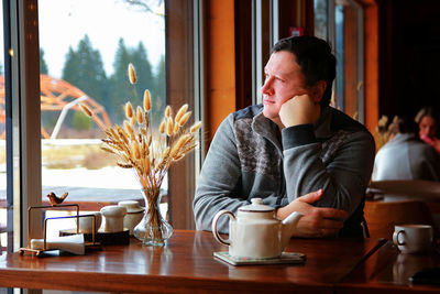 Man looking away while sitting at restaurant