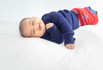 Infant boy lying cute facial expression with white background at indoor