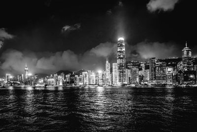 Illuminated modern buildings in city against sky at night