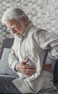 Side view of man sitting on sofa at home