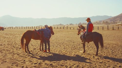 Men riding horse in ranch