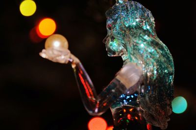 Close-up of illuminated statue against black background