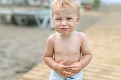 Close-up of sad cute boy standing outdoors