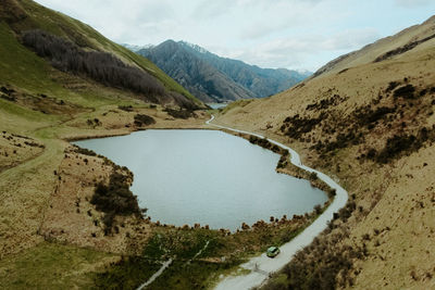 Scenic view of lake by mountains against sky