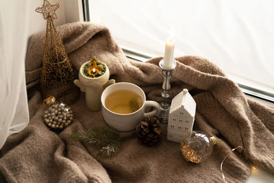 Hot tea, candles, christmas golden balls and decorations. christmas holiday mood