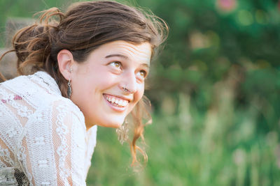 Portrait of smiling young woman standing against plants