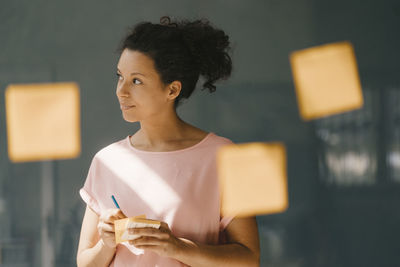 Woman brainstorming in office usine adhesive notes