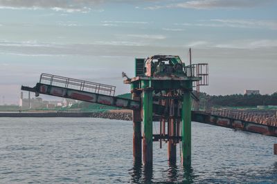 Lifeguard hut on bridge over sea against sky