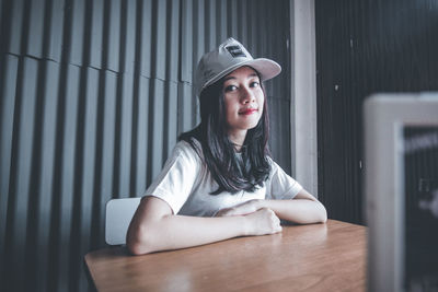 Portrait of young woman sitting at table in cafe