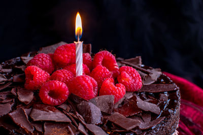 Chocolate cake with fresh raspsberries and a birthday candle