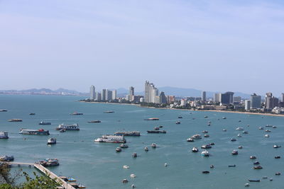 High angle view of city by sea against sky