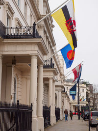 Low angle view of flags against buildings in city