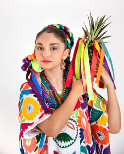 Portrait of young woman with multi colored hair against white background