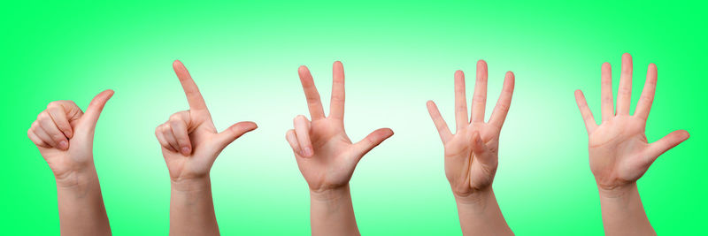 Cropped hands gesturing against green background