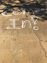 High angle view of text on sand