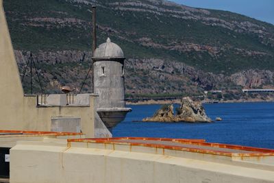 Building by sea against mountain