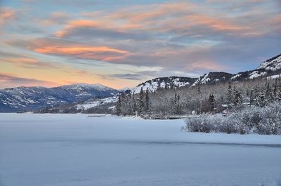 Scenic view of snowcapped mountains against sky during sunset