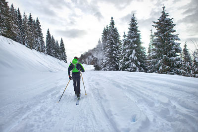 Man skiing on snowcapped mountain against sky