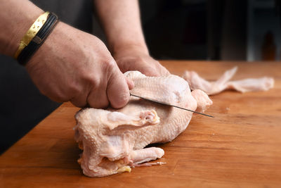 Midsection of man preparing food on cutting board