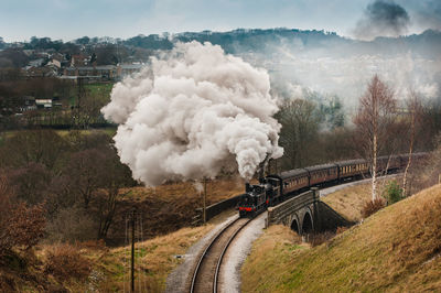 High angle view of train emitting smoke by trees