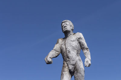 Low angle view of statue against blue sky