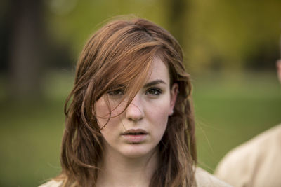 Close-up portrait of young woman with tousled hair