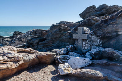 Stone wall by sea against clear sky