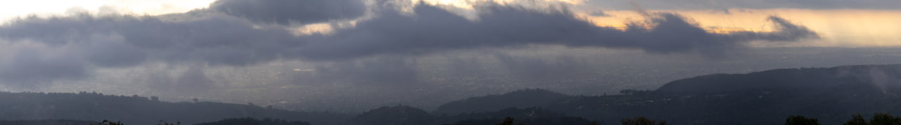 Panoramic view of trees and mountains against sky