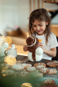 Portrait of girl with ice cream on table at home