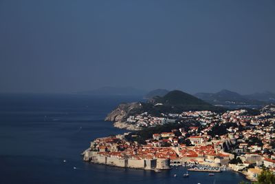 High angle view of townscape by sea against clear sky