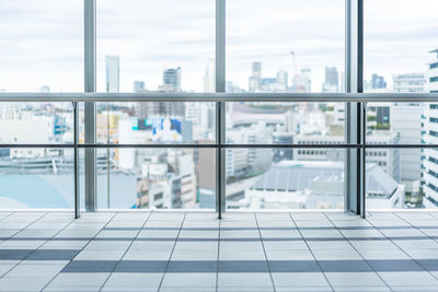 Buildings against sky seen through glass window