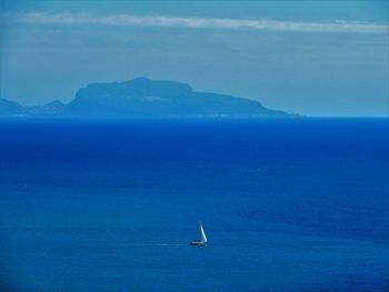 Sailboat in sea against blue sky