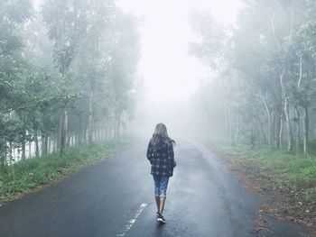 Woman with umbrella on road in rain