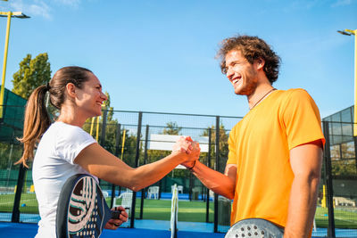 Smiling athletes shaking hands outdoors