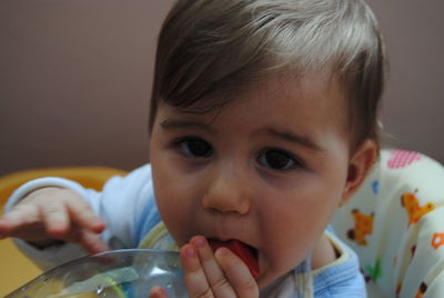 Portrait of cute boy holding bottle at home