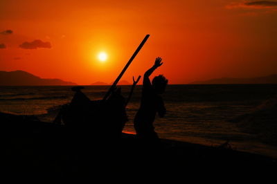 Silhouette people at beach during sunset