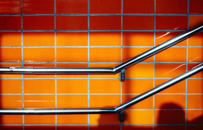 Close-up of railing against orange wall