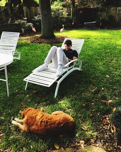 Boy sitting on chair in lawn