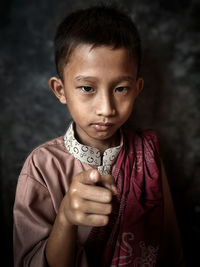 Portrait of young man against black background