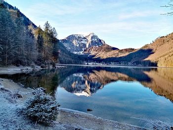 Scenic view of lake by snowcapped mountains against sky