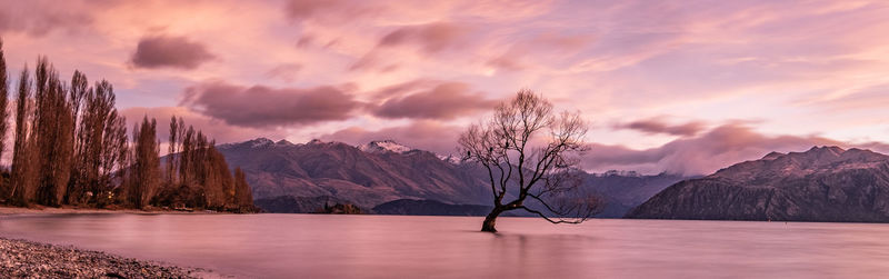 Scenic view of lake and mountains against sky at sunset
