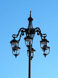 Low angle view of old street light against clear blue sky