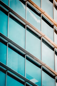 Modern business office building windows pattern with blue sky reflecting on background.