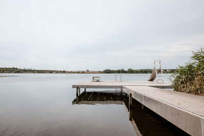 Scenic view of swimming pool by lake against sky