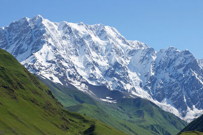 Scenic view of snowcapped mountains against clear sky