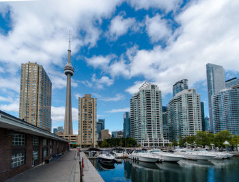 View of buildings in city against cloudy sky