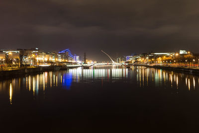 Illuminated bridge over river at night